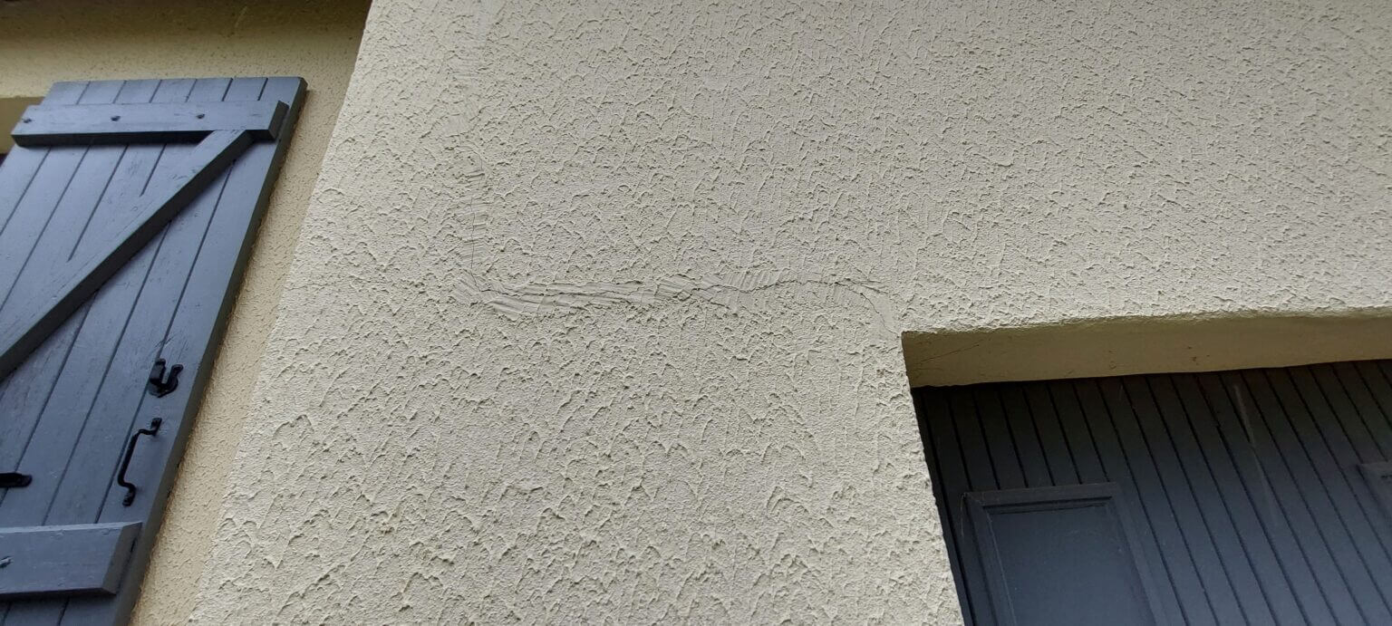 Photo d'une fissure d'un mur extérieur qui été camouflée