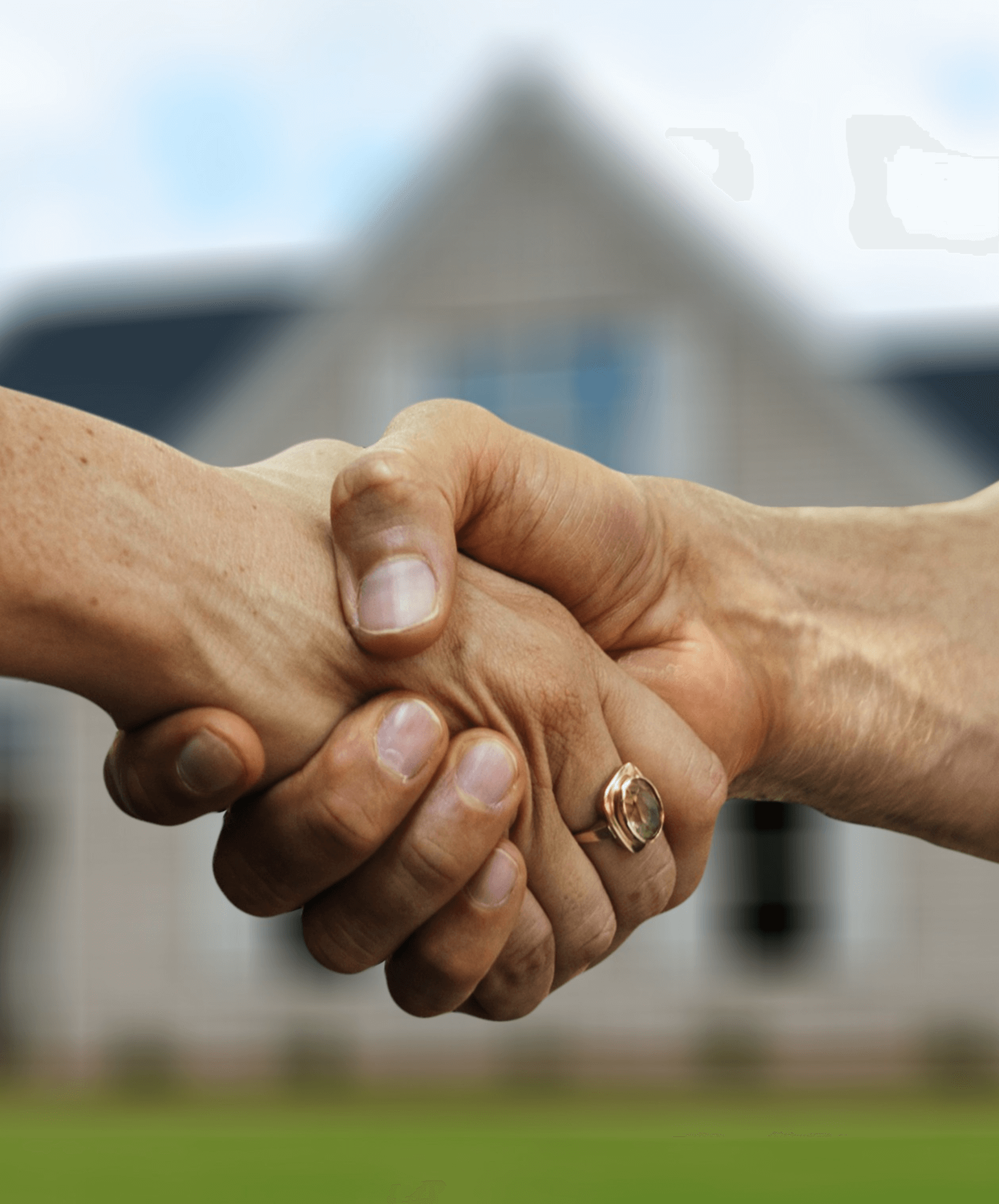 Zoom sur un serrage de mains avec en fond la photo d'une maison.