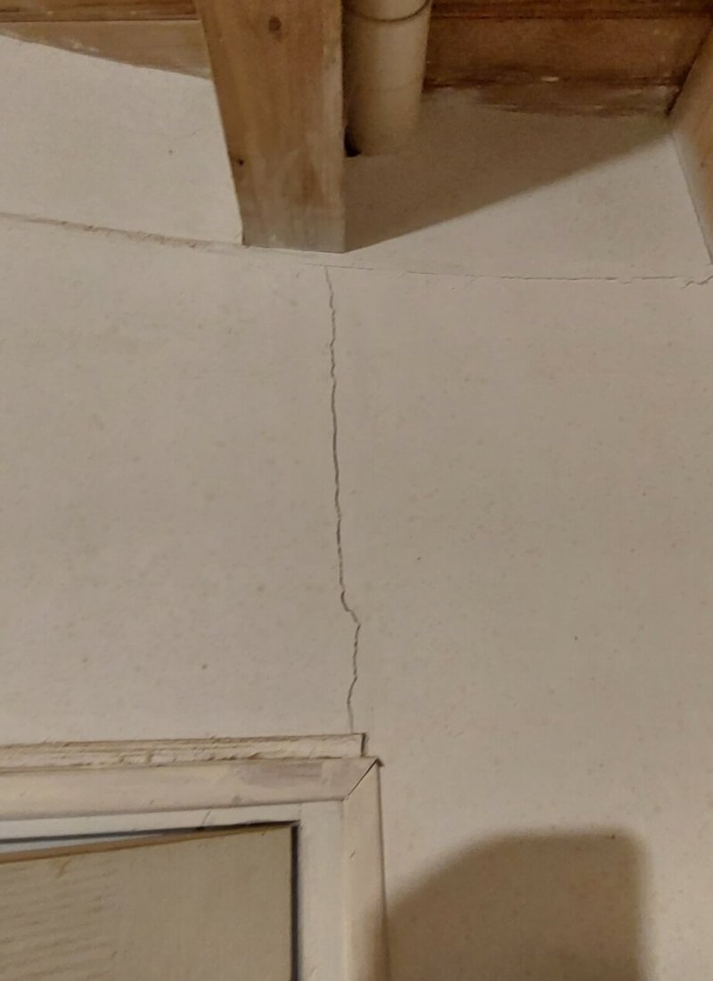 photo d'une fissure traversante qui part de la poutre jusqu'à l'imposte d'une porte